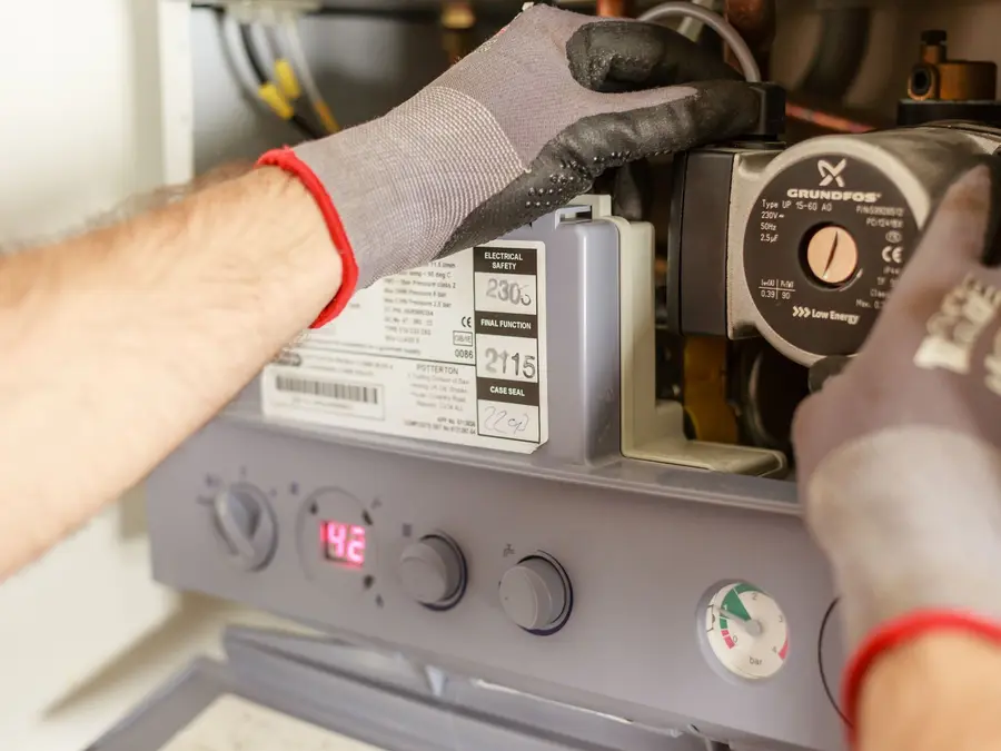Technician's hands servicing a home heating system
