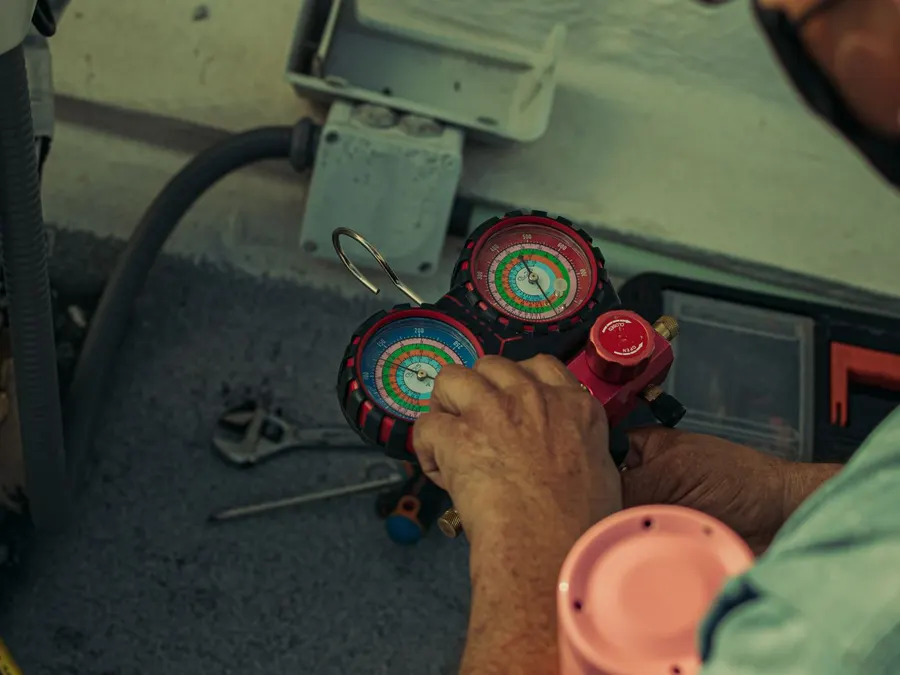 Manifold gauges connected to an air conditioner during a repair visit